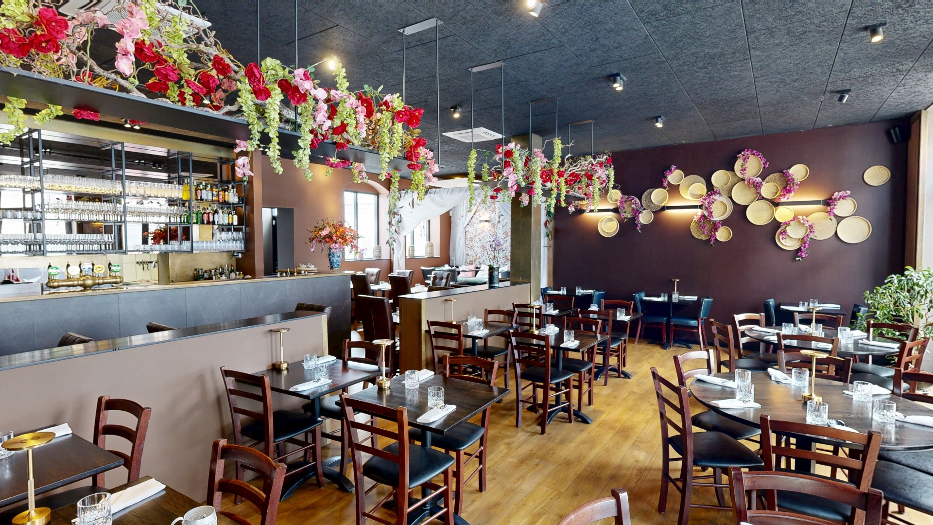 Mik Mik Thai Restaurants nyrenoverede lokaler med blomsterdekorationer, bordeaux vægge og elegant borddækning